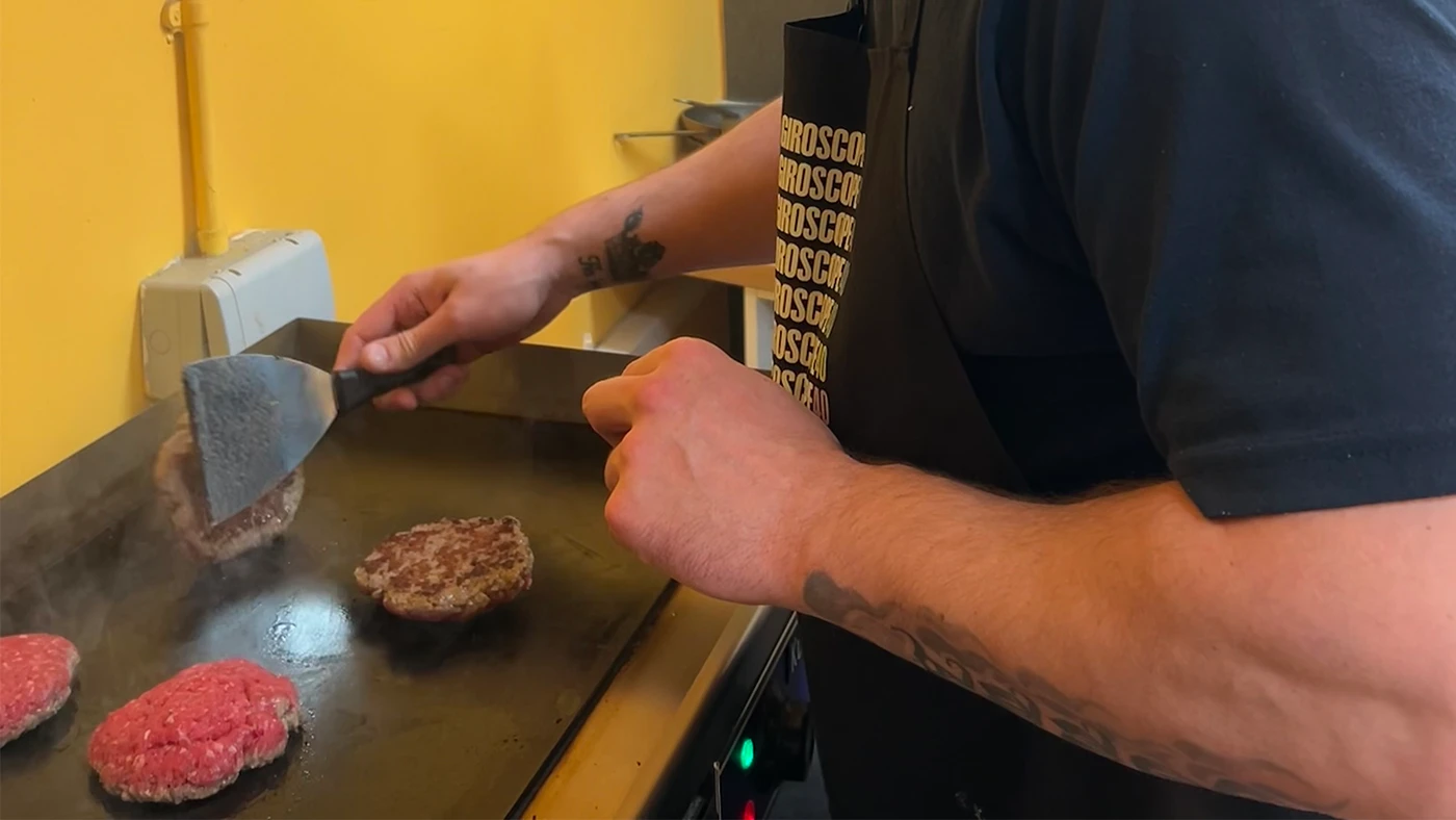 Man frying burgers on a hotplate