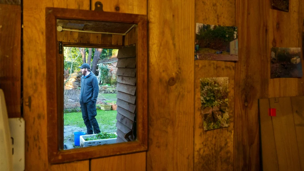 Volunteer at Sycamore Gardening seen through shed window